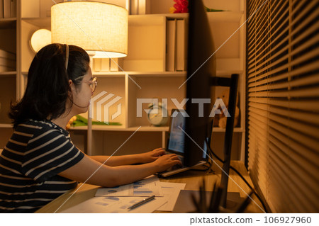Late-Night Online Education, Dedicated Young Woman Studying Online Late at Night in Her Home Office, Work for home. Late-Night Online Education, Dedicated Young Woman Studying Online Late at Night in Her Home Office, Work for home. 106927960