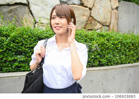 A woman calling on a smartphone outdoors 106928065