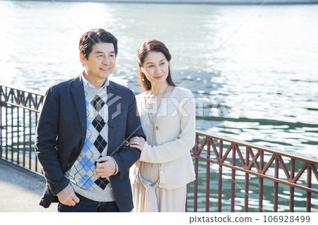 A middle-aged couple having a date by the river in the city 106928499