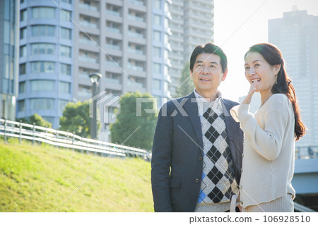 A middle-aged couple having a date by the river in the city A middle-aged couple having a date by the river in the city 106928510