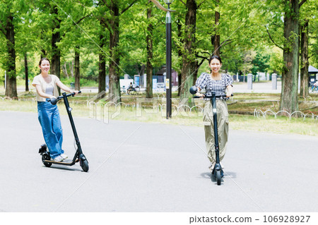 A young woman running refreshingly on an electric kickboard A young woman running refreshingly on an electric kickboard 106928927