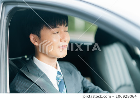 一名穿西裝的男子開車時犯困 一名穿西裝的男子開車時犯困 106929064