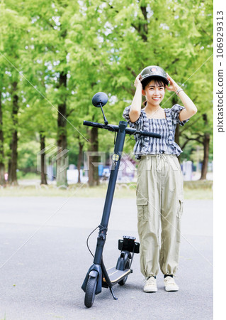 Electric kickboard, woman wearing a helmet Electric kickboard, woman wearing a helmet 106929313