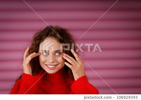 Young red haired woman touching face with fingers doing face yoga facial gymnastics self massage and facebuilding exercise 106929393