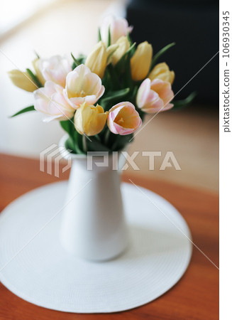 Spring tulips in a vase on the table. Spring holiday, home decor. Spring tulips in a vase on the table. Spring holiday, home decor. 106930345