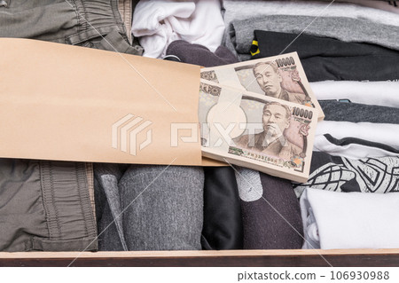 [Wad of bills in envelopes hidden in the drawer] 106930988