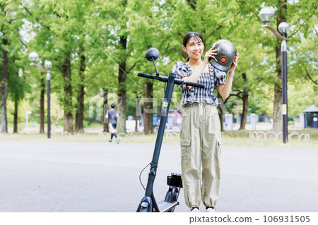 Electric kickboard, woman wearing a helmet Electric kickboard, woman wearing a helmet 106931505