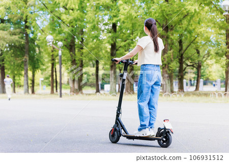 一位年輕女子在電動滑板上清爽地奔跑 106931512