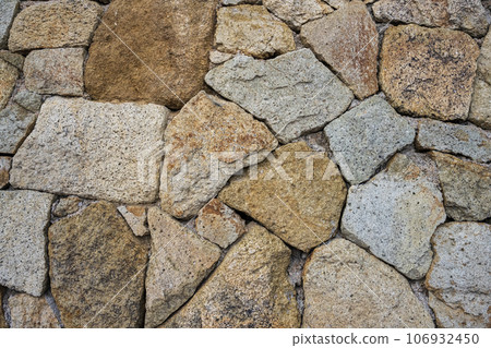 Fragment of a natural stone wall as a background or texture. The structure of the stone wall. Old castle stone wall texture background. Fragment of a natural stone wall as a background or texture. The structure of the stone wall. Old castle stone wall texture background. 106932450