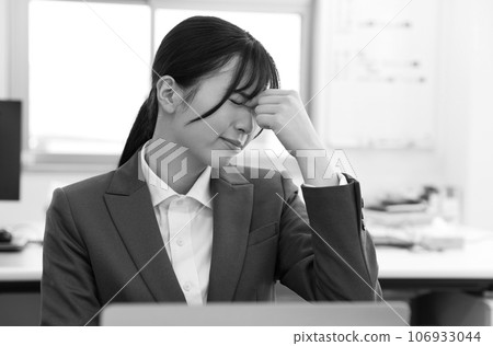 Monochrome image of a tired female office worker 106933044