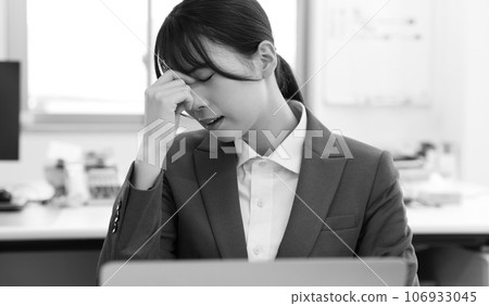 Monochrome image of a tired female office worker 106933045