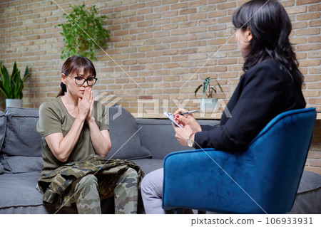 Middle-aged military woman talking with professional psychologist Middle-aged military woman talking with professional psychologist 106933931