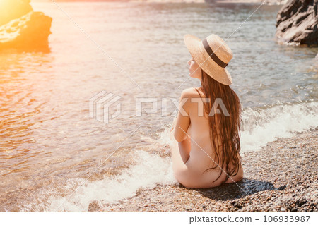 Woman travel sea. Happy tourist in hat enjoy taking picture outdoors for memories. Woman traveler posing on the beach at sea surrounded by volcanic mountains, sharing travel adventure journey Woman travel sea. Happy tourist in hat enjoy taking picture outdoors for memories. Woman traveler posing on the beach at sea surrounded by volcanic mountains, sharing travel adventure journey 106933987