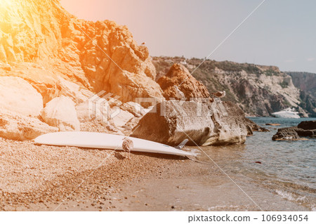 Woman summer travel sea. Happy tourist enjoy taking picture outdoors for memories. Woman traveler posing on the beach at sea surrounded by volcanic mountains, sharing travel adventure journey Woman summer travel sea. Happy tourist enjoy taking picture outdoors for memories. Woman traveler posing on the beach at sea surrounded by volcanic mountains, sharing travel adventure journey 106934054