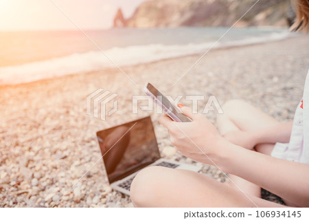 Woman sea laptop. Business woman in yellow hat working on laptop by sea. Close up on hands of pretty lady typing on computer outdoors summer day. Freelance, digital nomad, travel and holidays concept. Woman sea laptop. Business woman in yellow hat working on laptop by sea. Close up on hands of pretty lady typing on computer outdoors summer day. Freelance, digital nomad, travel and holidays concept. 106934145