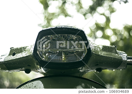 Close up green motorcycle scooter with raindrops 106934689