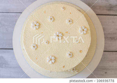 White delicate Raffaello cake with flowers on a gray wooden table top view. 106936778