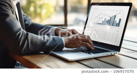 Male financial analyst in eyeglasses works in front of a laptop monitor. 106937070