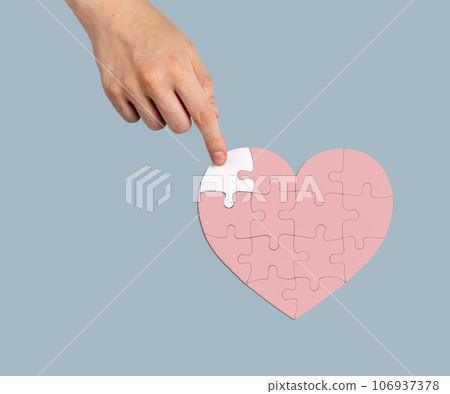 Adding the missing puzzle piece to heart-shaped jigsaw. Help, aid, donation concept 106937378