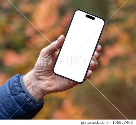 Hand holding mobile phone screen mock up over fall background Hand holding mobile phone screen mock up over fall background 106937408