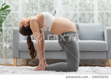 Happy Attractive Asian Pregnant woman practice yoga Ustrasana pose or yoga Camel pose to meditation smile with big belly after wake up in morning comfortable and relax.Pregnant yoga concept Happy Attractive Asian Pregnant woman practice yoga Ustrasana pose or yoga Camel pose to meditation smile with big belly after wake up in morning comfortable and relax.Pregnant yoga concept 106938050