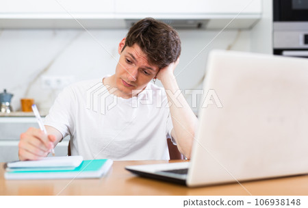 Young guy studying at home with laptop 106938148