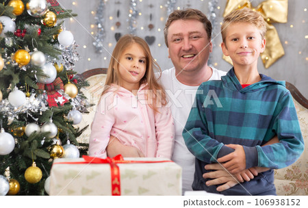 Happy father with his son and daughter near the Christmas tree in the living room 106938152