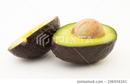 Halved avocado with bone on white background Halved avocado with bone on white background 106938161