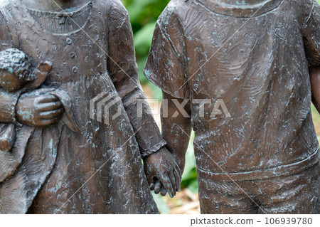 Childhood Statue boy and girl holding hand close up on body and hand 106939780