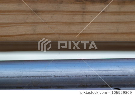 close up of metal pipe tube and wood background 106939869
