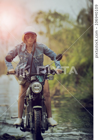 woman wearing jeans collection riding enduro motorcycle crossing shallow water track woman wearing jeans collection riding enduro motorcycle crossing shallow water track 106940109