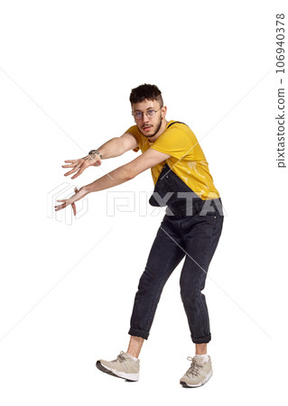 Full-length portrait of a funny guy dancing in studio isolated on white background. 106940378
