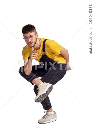 Full-length portrait of a funny guy dancing in studio isolated on white background. 106940388