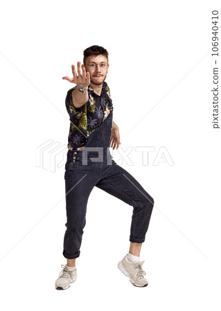 Full-length portrait of a funny guy dancing in studio isolated on white background. 106940410