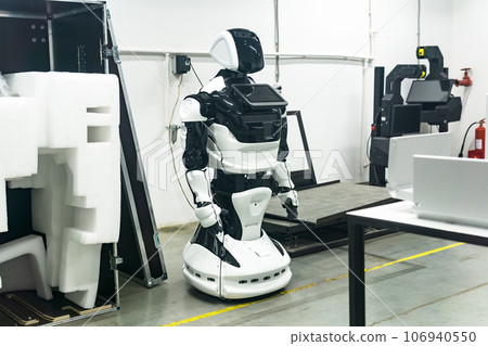 newly assembled humanoid robot in a workshop is being charged before packaging newly assembled humanoid robot in a workshop is being charged before packaging 106940550