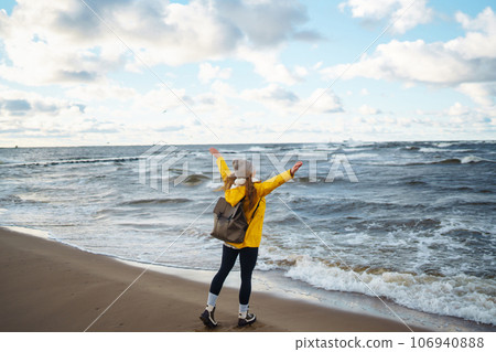 Happy tourist in a yellow jacket enjoying sea landscape at sunset. Travelling, lifestyle, adventure. Happy tourist in a yellow jacket enjoying sea landscape at sunset. Travelling, lifestyle, adventure. 106940888
