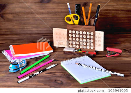 Pencils and calendar on brown wooden background Pencils and calendar on brown wooden background 106941095