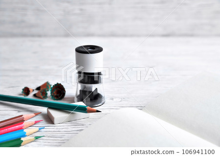 Pencils, notepad, sharpener, eraser and shavings from pencils on a gray non-uniform background Pencils, notepad, sharpener, eraser and shavings from pencils on a gray non-uniform background 106941100