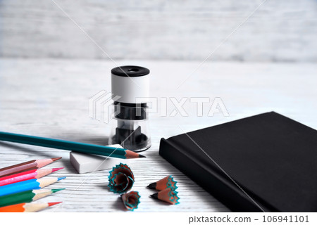 Pencils, notepad, sharpener, eraser and shavings from pencils on a gray non-uniform background 106941101