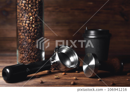 temper portafilter cardboard glass for coffee on a brown wooden background close-up copy space temper portafilter cardboard glass for coffee on a brown wooden background close-up copy space 106941216