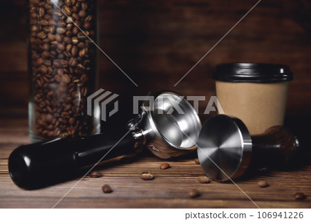 temper portafilter cardboard glass for coffee on a brown wooden background close-up copy space 106941226