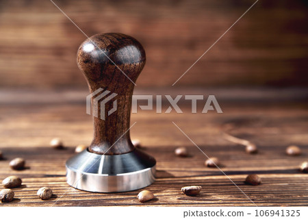 temper coffee beans on a brown wooden background blur 106941325
