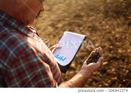 Farmer is checking soil quality before sowing. Agriculture, gardening or ecology concept. 106941374
