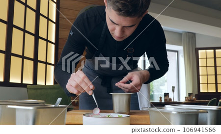 Healthy organic food. The cook prepares a salad with cucumber and radish, the cook prepares a light salad, vegetarian food, a handsome caucasian male cook presents a delicious dish 106941566