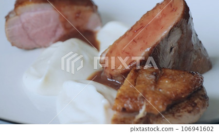 Close-up of a juicy freshly cooked steak. The male chef makes the composition of the dish for serving. Professional chef in the restaurant kitchen serving a dish Close-up of a juicy freshly cooked steak. The male chef makes the composition of the dish for serving. Professional chef in the restaurant kitchen serving a dish 106941602