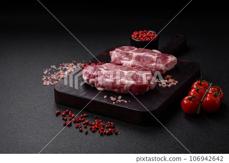 Fresh juicy pork steaks with salt, spices and herbs 106942642