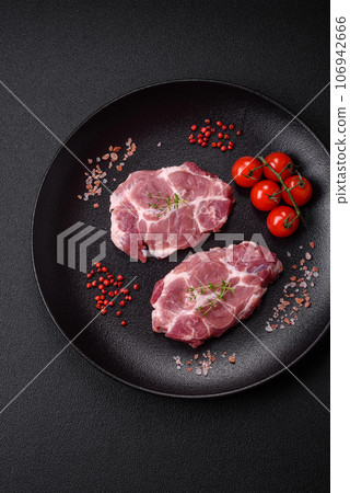 Fresh juicy pork steaks with salt, spices and herbs 106942666