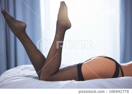 Sexy in stockings. an unrecognizable young woman in lingerie lying on her bed at home. 106942778