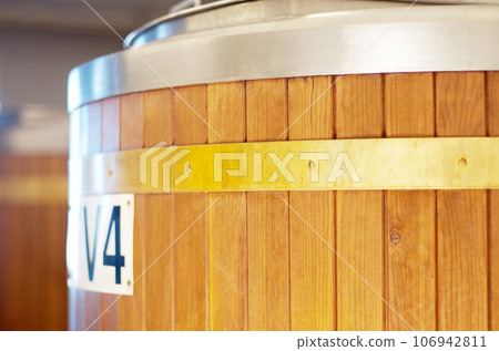 Brewery, keg and barrel for beer, alcohol and brewing process in warehouse. Wooden, drum and alcoholic beverage at a distillery for storage, fermentation and manufacturing, industry or tank system 106942811