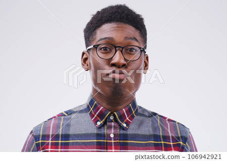Funny face, young and portrait of a black man pouting isolated on a white background in a studio. Geek, pout and a face headshot of an African person with glasses as a nerd, goofy and quirky Funny face, young and portrait of a black man pouting isolated on a white background in a studio. Geek, pout and a face headshot of an African person with glasses as a nerd, goofy and quirky 106942921